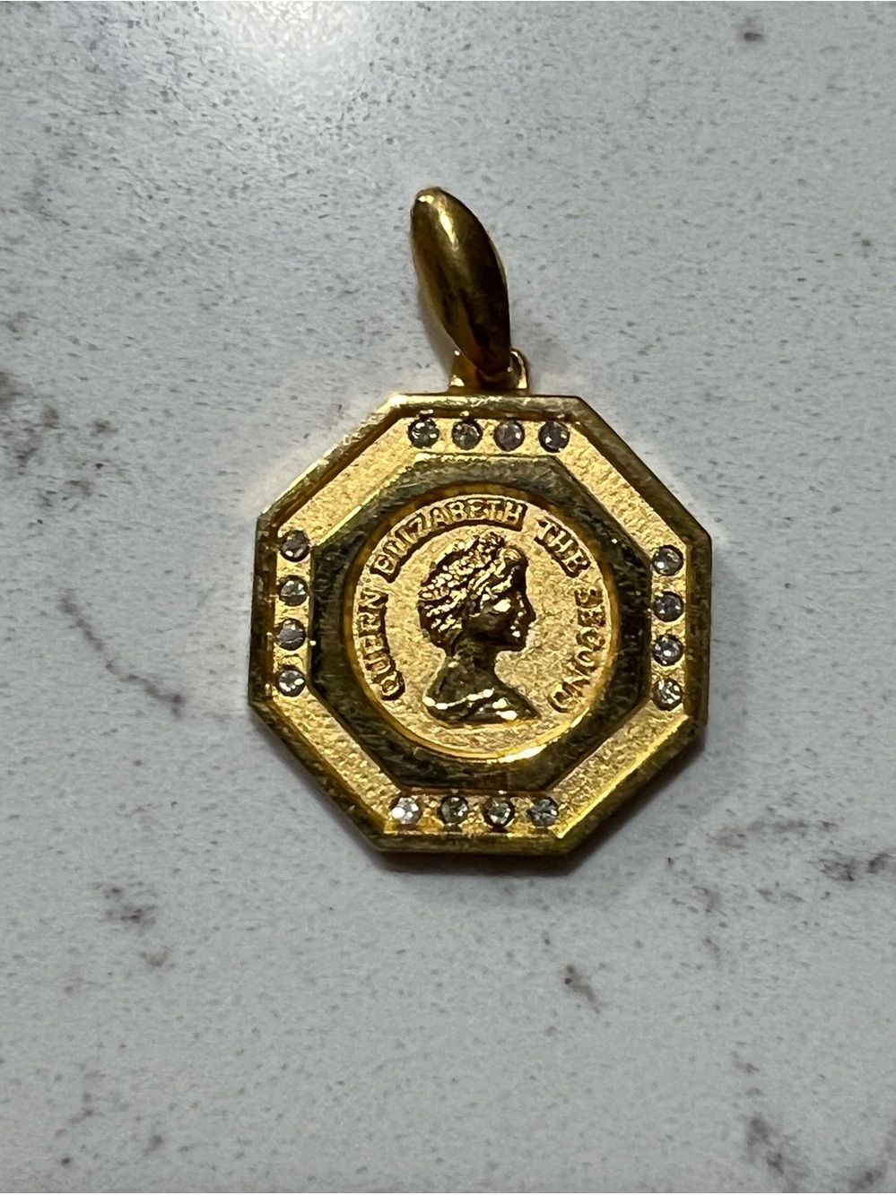 Gold-tone octagonal pendant featuring Queen Elizabeth II surrounded by crystals.